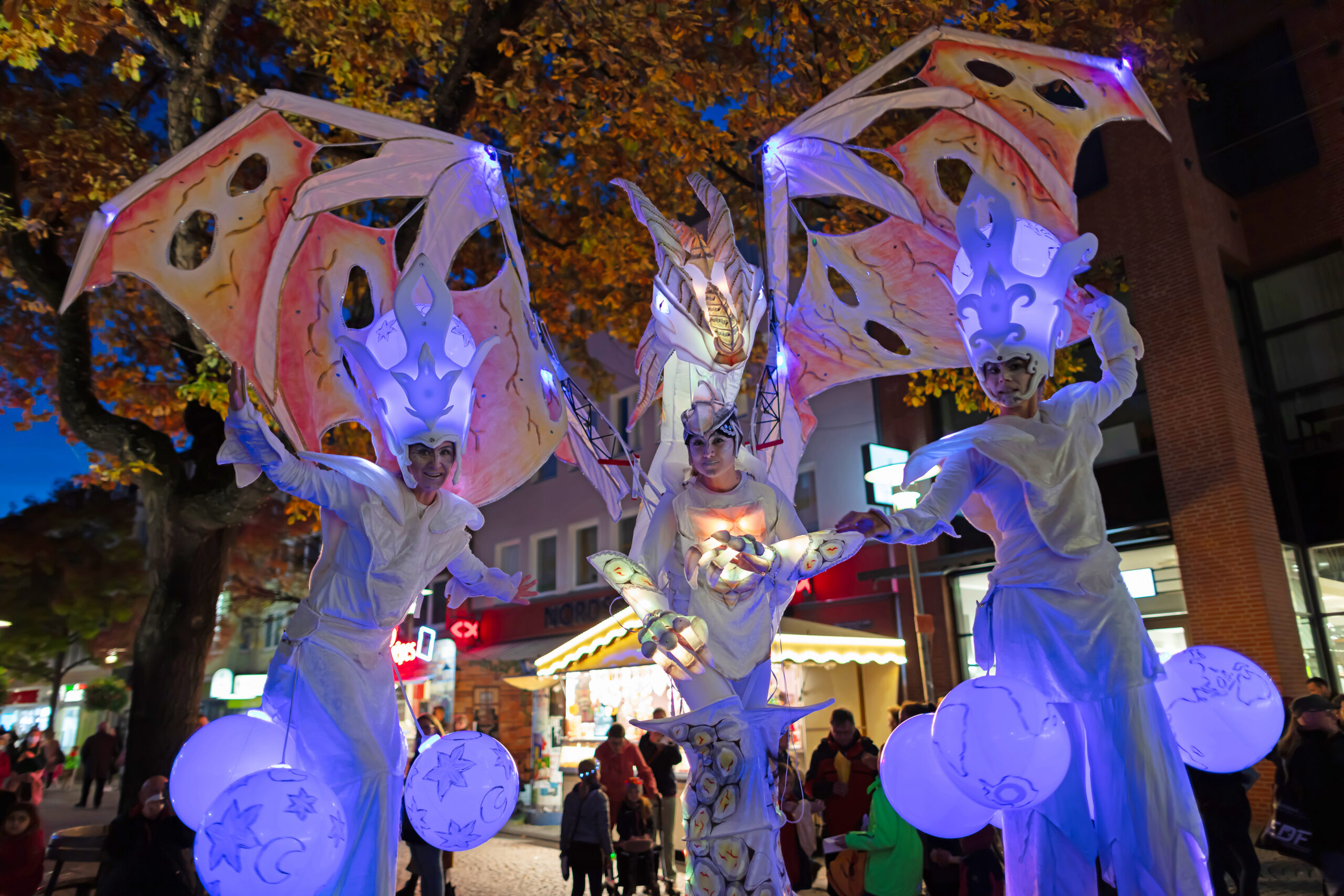 leuchtender Drache faltet seine Flügel über den Lichtwesen aus