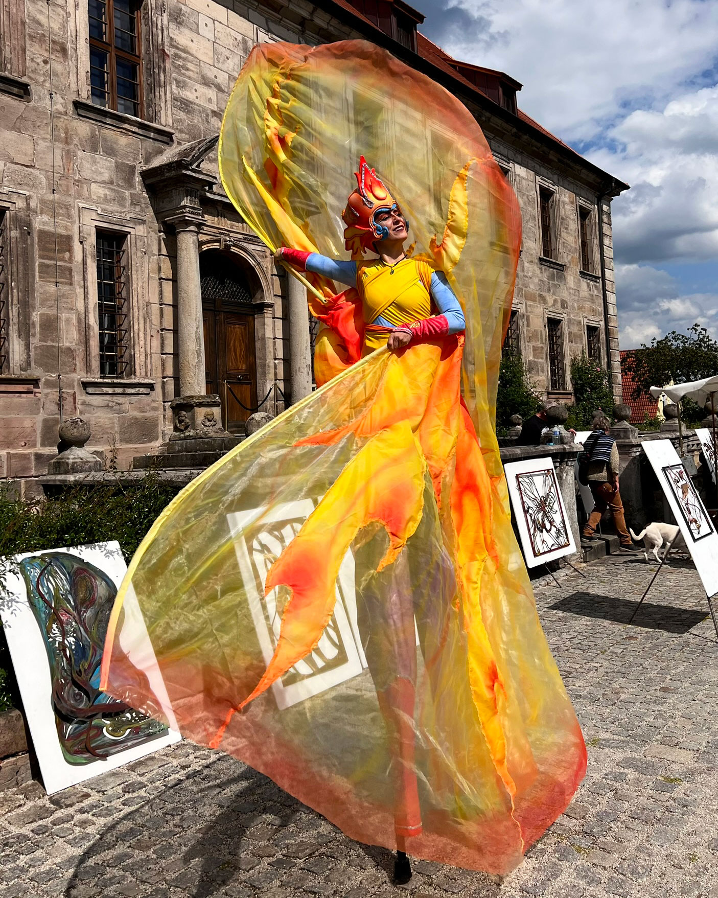 Walking Act auf Stelzen als Feuer