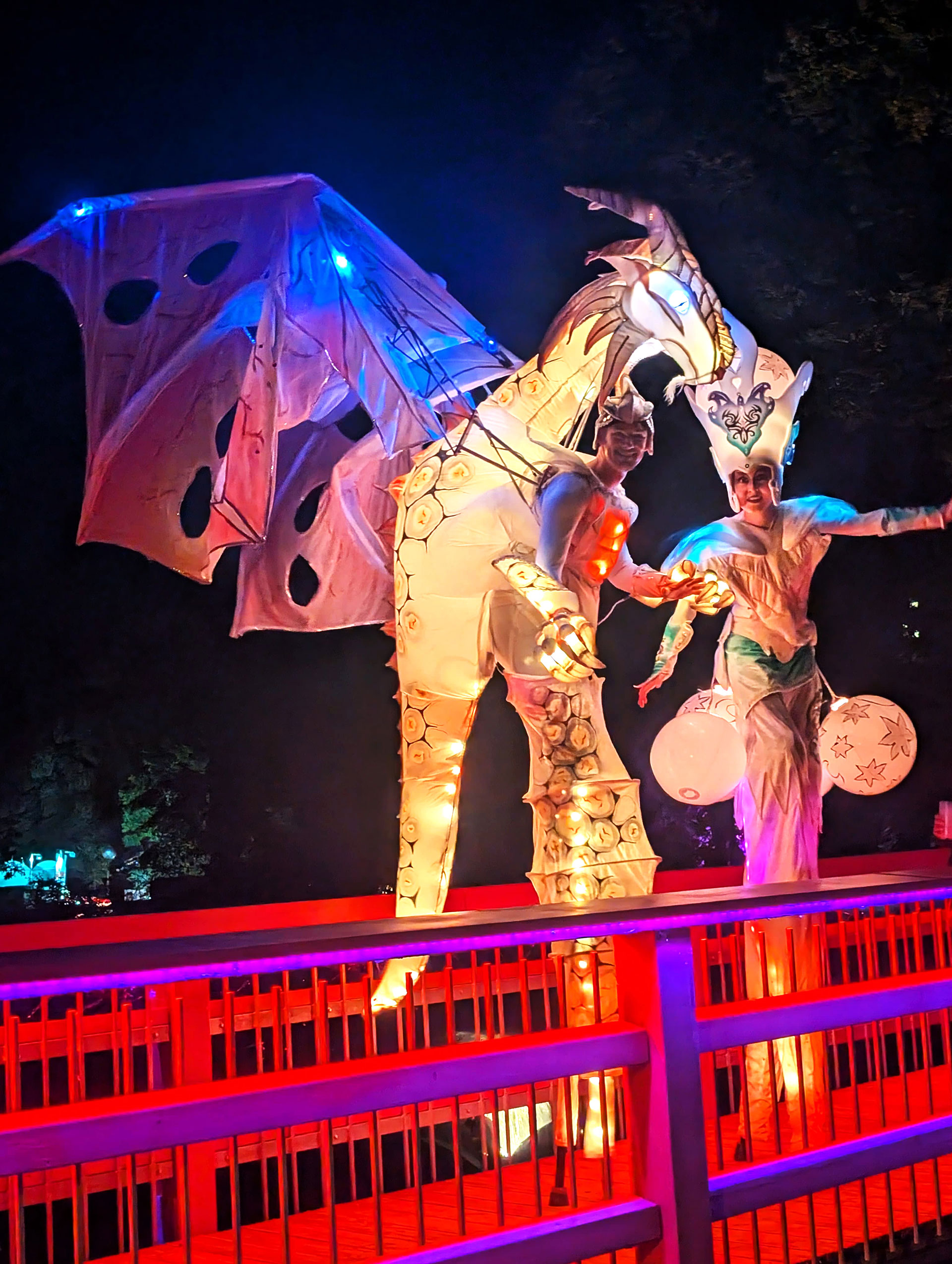 Leuchtender Drache und buntes Lichtwesen auf der Brücke